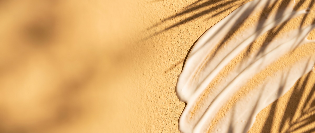 Zonnebrandcrème in zonlicht met palmschaduw